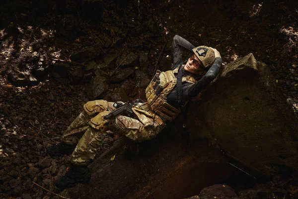 Женщина в военной форме расслабляется на groud — стоковое фото