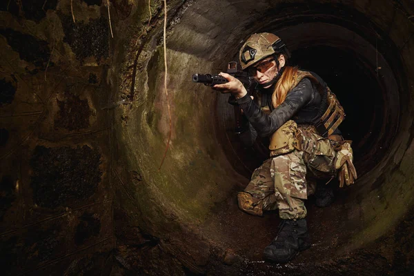 Female person walking through pipe in search of target — Stock Photo, Image