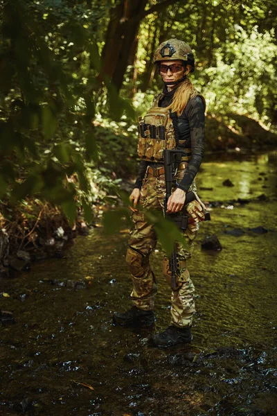 Солдат в камуфляжной группировке проходит через водохранилище — стоковое фото