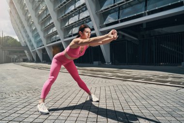 Aktif kadın öne eğiliyor ve kollarını açıyor.