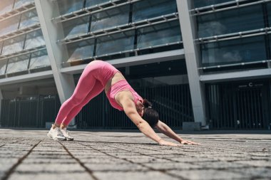 Kadın yere yaslanırken sırtını eğiyor.