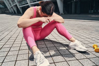 Egzersiz yaptıktan sonra gülen kadın yüzünü kapatıyor.