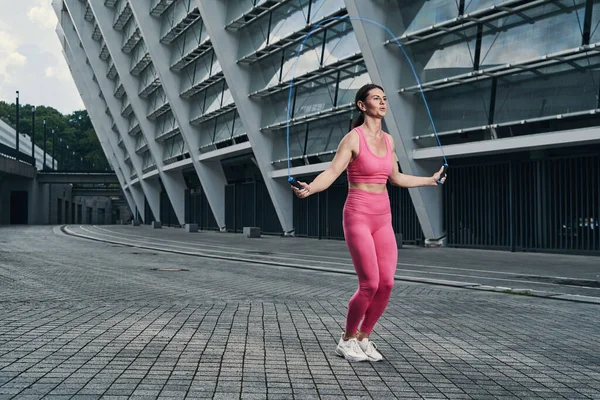 Mulher pulando com corda de salto fora do edifício — Fotografia de Stock