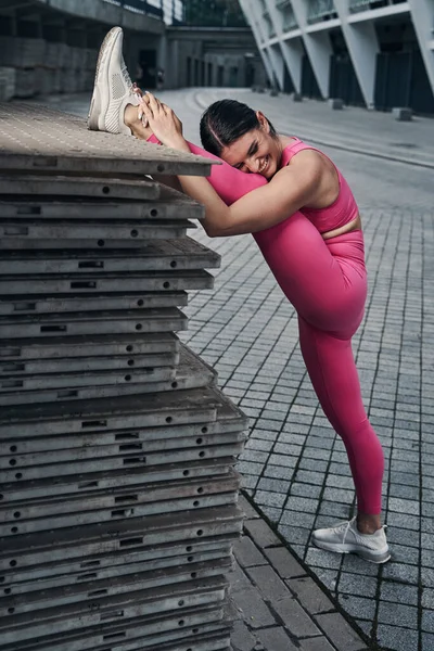 Training female putting head on her leg and laughing — Stock Photo, Image