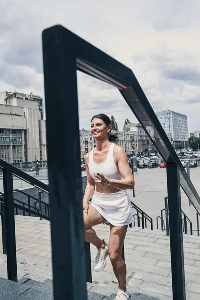 Lady njuter av sin jogging medan hon rör sig genom trappor — Stockfoto