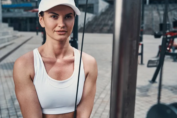 Attraktive Frau trainiert Armmuskeln mit Seilzug — Stockfoto