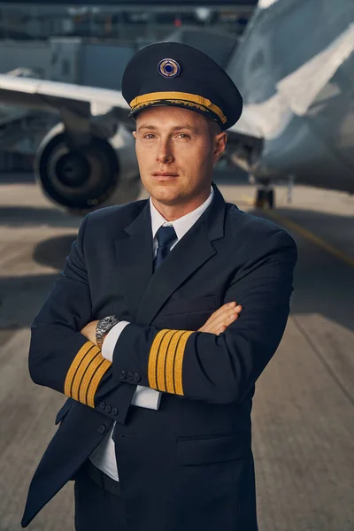 Aviador en uniforme y gorra posando para la cámara — Foto de Stock