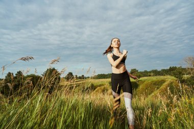 Sporcu kadın yaz günü dışarıda antrenman yapıyor.