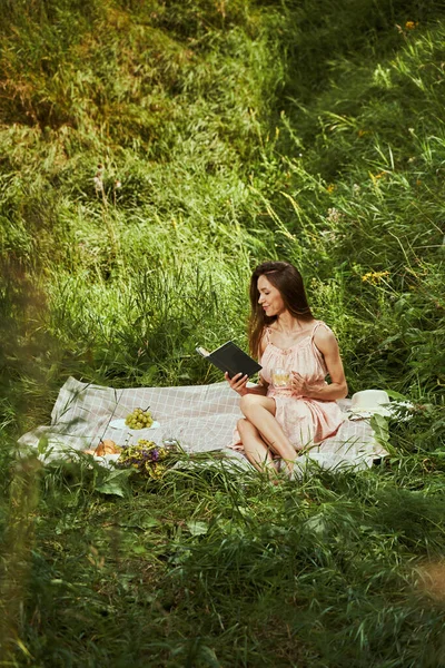 야외에서 가장 좋아 하는 책을 즐기는 아름다운 여인 — 스톡 사진