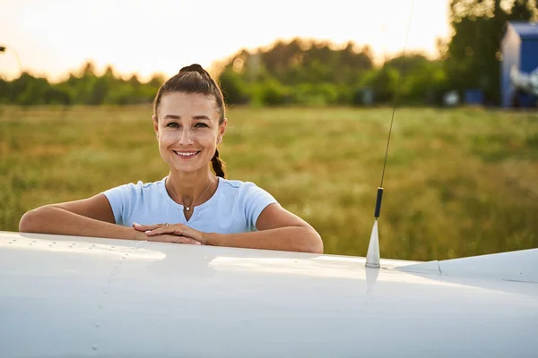 Joven mujer increíble apoyándose en el avión privado — Foto de Stock