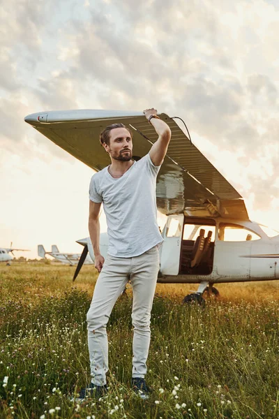 Un buen piloto posando cerca de su pequeño avión —  Fotos de Stock