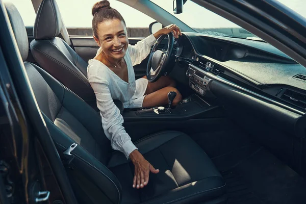 Mulher convidando uma pessoa para ter um assento no carro — Fotografia de Stock