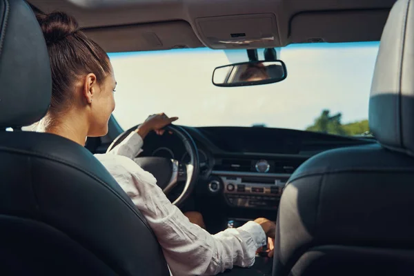 Vue arrière de la personne réglant les rapports de voiture pendant la conduite — Photo