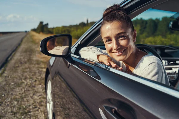 Joyful driver looking out of car window — Stock Photo, Image