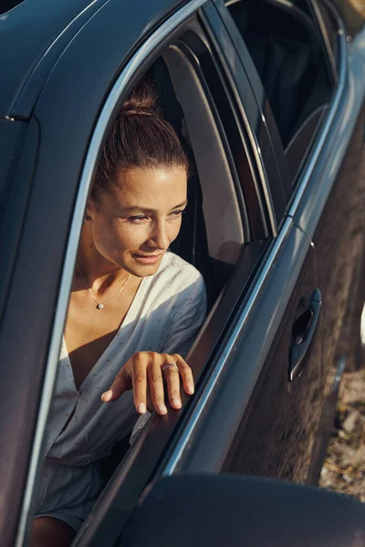 Kobieta patrząca przez otwarte okno samochodu — Zdjęcie stockowe