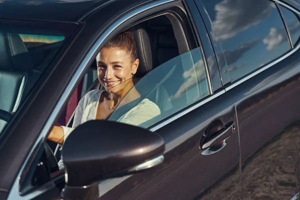 Frau lächelt zufrieden aus ihrem Auto — Stockfoto
