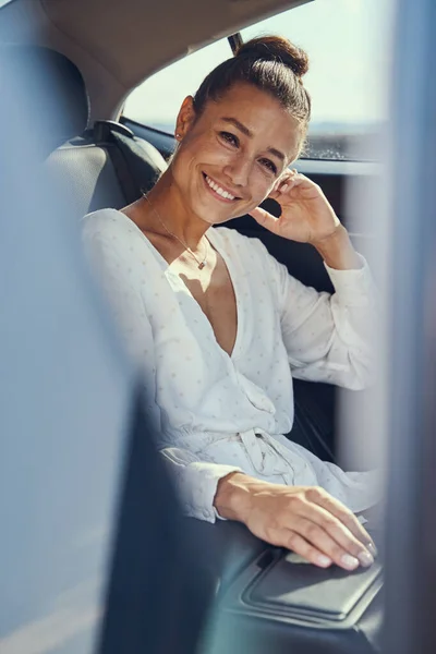 Feminino no carro sorrindo para uma foto do banco traseiro — Fotografia de Stock