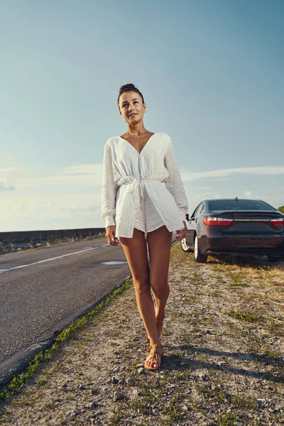 Mujer caminando en la acera de la carretera desde su auto — Foto de Stock