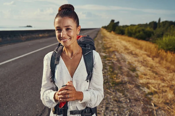 白人女性徒步旅行时检查道路上的车辆 — 图库照片