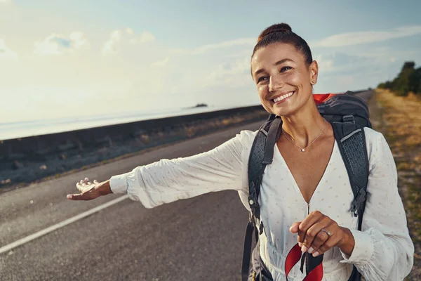 Hitchhiker giving a sign to cars to stop — Stock Photo, Image