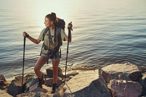 Sırt çantalı, göl kıyısındaki taşlarda yürüyor. — Stok fotoğraf