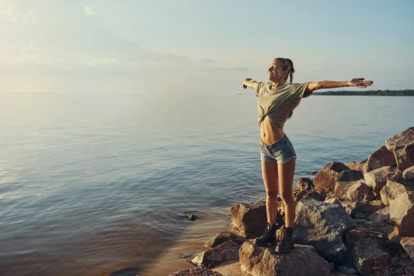 Volný žena roztahování paže a těší vítr — Stock fotografie