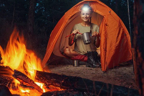 Camper mixing drink in metal pot with plastic spoon — Stock Photo, Image