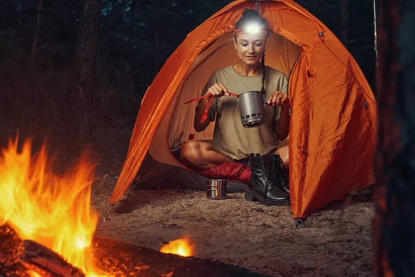 Tourist benutzt Campinggeschirr, um Tee aus Kanne zu holen — Stockfoto