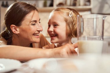 Mutlu kız yemek pişirirken ailesiyle gülüyor.