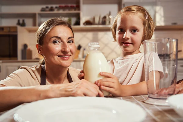 Niño y adulto sosteniendo biberón de leche y mirando a la cámara —  Fotos de Stock