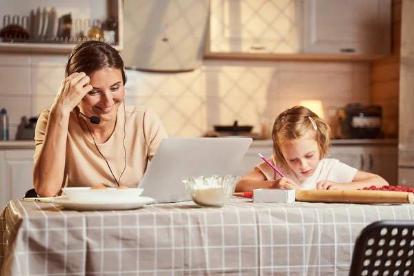 Madre ridere durante l'incontro online mentre sua figlia disegno — Foto Stock