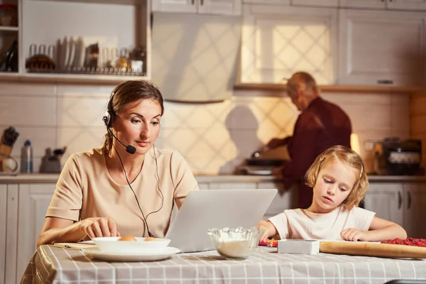 Adulti che indossano con il computer con nonna che cucina in background — Foto Stock