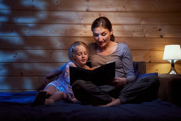 Matka čte pohádky před spaním svému dítěti — Stock fotografie