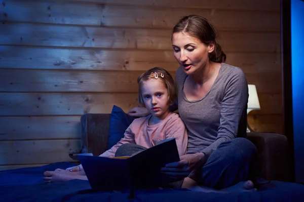 Signora che tiene un libro e racconta una storia a un bambino — Foto Stock