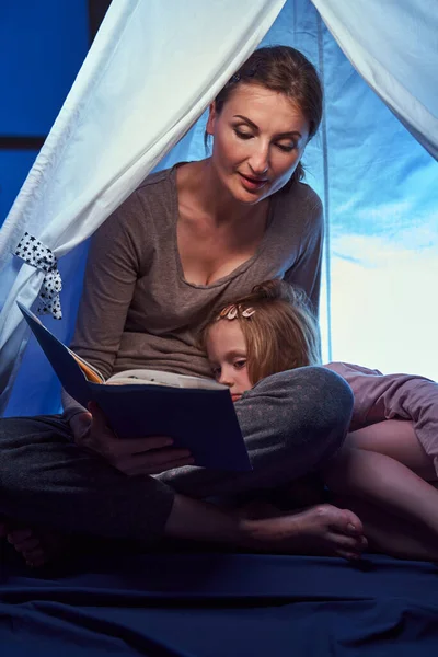 Menina que adormece na tenda da cama enquanto ouve histórias — Fotografia de Stock
