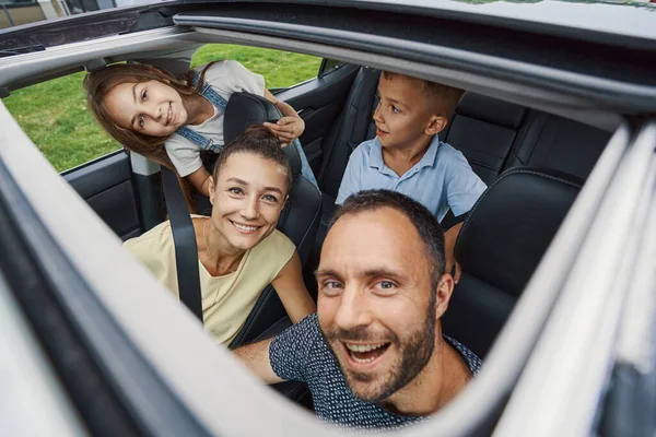 Familia de cuatro personas sintiéndose emocionada antes del viaje por carretera — Foto de Stock