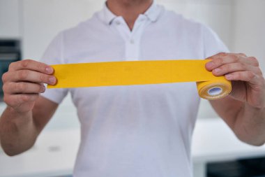 Adam kinesiyolostin beyaz gömlek ve kollarında parlak bant ile tıp merkezinde önünde