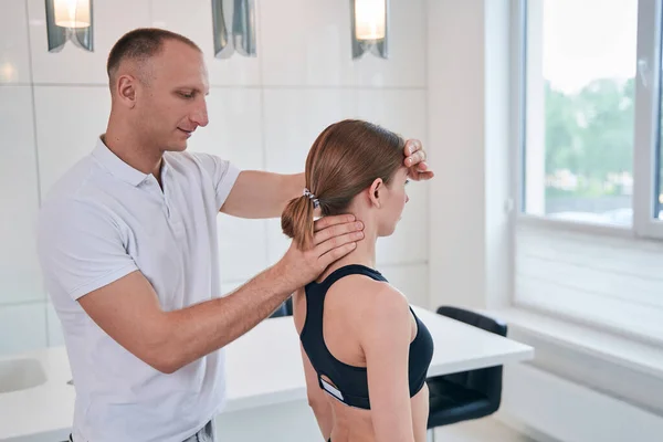 Handsome male massage therapist working with woman patient in wellness center — Stock Photo, Image