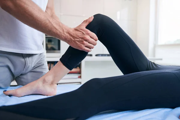 Mooie elegante vrouw ontvangt professionele manuele therapie in haar knie in wellness centrum — Stockfoto