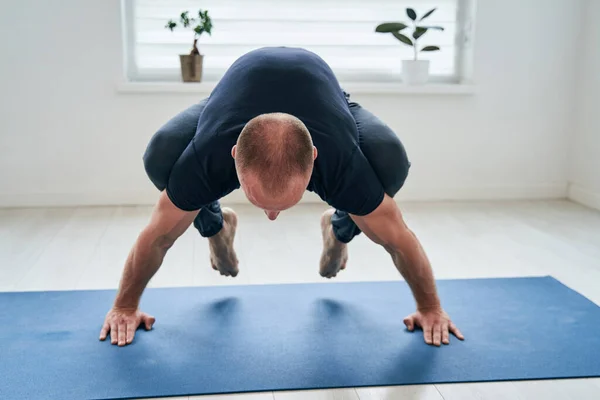 Snygg stark manlig gymnast balansera hälsa banner med övning som sträcker sig i hemklassen — Stockfoto