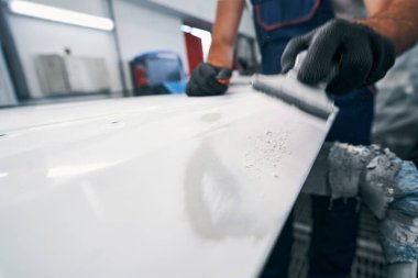 El zımparası metalden beyaz boya çıkarıyor.