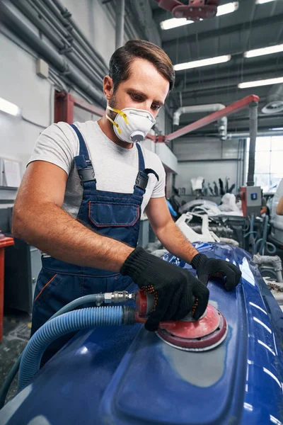 Auto mechanic in respirator using sander on car surface — Stock Photo, Image