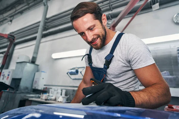 Automotive repairman checking quality of grinded surface — Stock Photo, Image