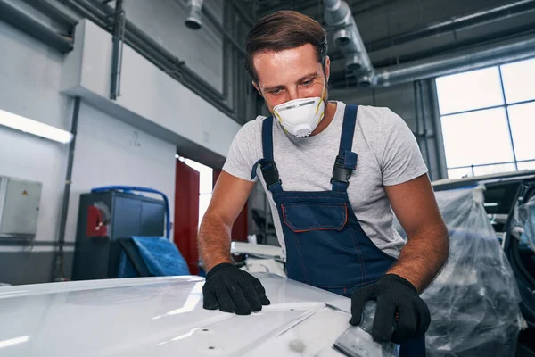 Worker of car paint workshop using hand sander — Stock Photo, Image