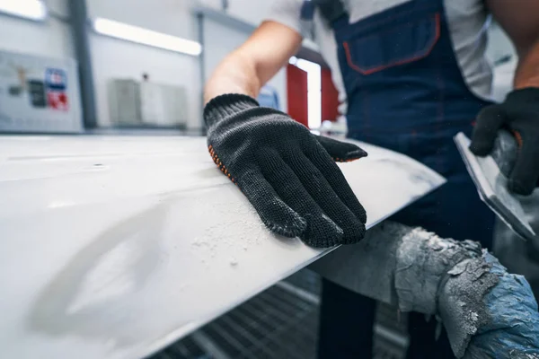 Naprawiający przesuwa dłoń na szlifowanej metalowej powierzchni. — Zdjęcie stockowe