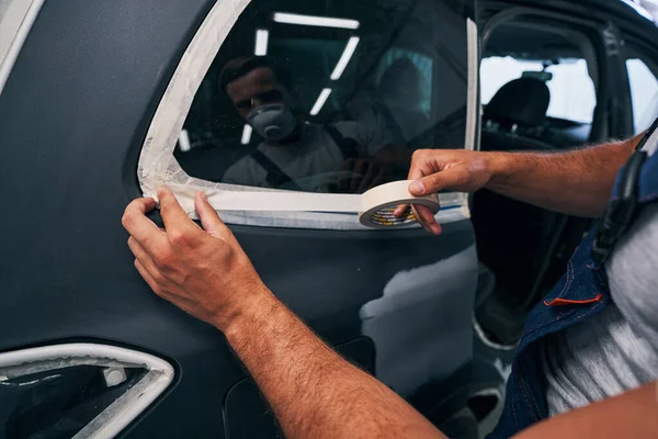 Persona aislando las ventanas del coche con cinta adhesiva — Foto de Stock