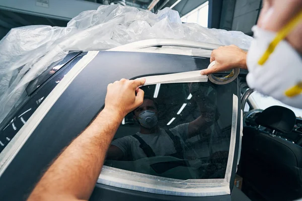 Técnico de servicio de coches pegando cinta adhesiva en la ventana —  Fotos de Stock