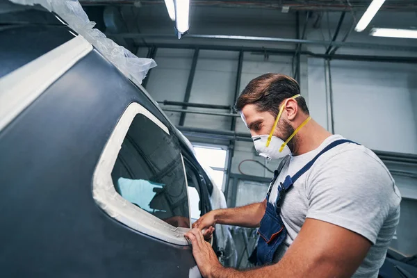 Muscular repairman putting duct tape on auto windows — Stock Photo, Image