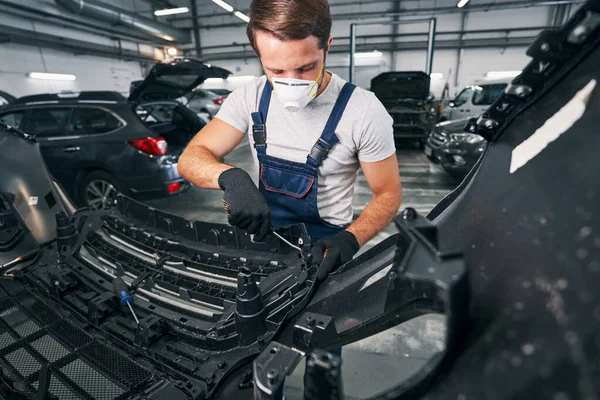 Reparador de coches alcanzando dentro de un coche con llave inglesa —  Fotos de Stock