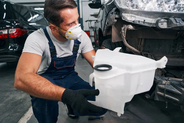 Reparador de coches quitando el contenedor de la lavadora de auto —  Fotos de Stock